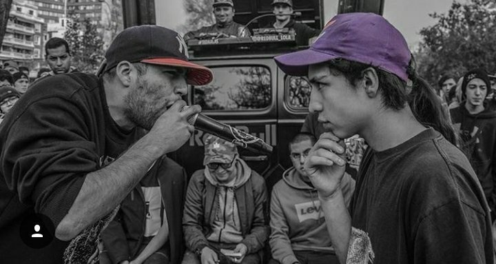 Dos freestylers en acción durante una batalla del evento Red Bull Batalla, mostrando creatividad y flow en cada rima.