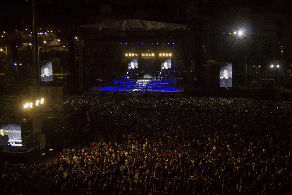Residente dará concierto gratis en el Zócalo de CDMX 9 Vista del escenario con Residente actuando frente a una gran multitud en el Zócalo de la Ciudad de México durante un concierto